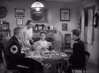 Movie still from “Fort Apache” (1948), directed by John Ford – An old photo of a family sitting at a table; Wide shot, High angle