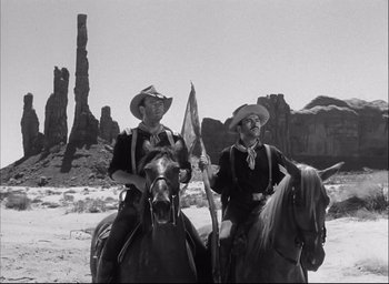Movie still from “Fort Apache” (1948), directed by John Ford – Two men on horseback in a desert area; Wide shot, Low angle