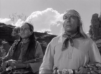 Movie still from “Fort Apache” (1948), directed by John Ford – Two native american men standing next to each other; Medium shot, Low angle
