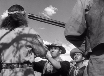 Movie still from “Fort Apache” (1948), directed by John Ford – A group of men standing next to each other on top of a hill; Medium shot, Over the shoulder angle