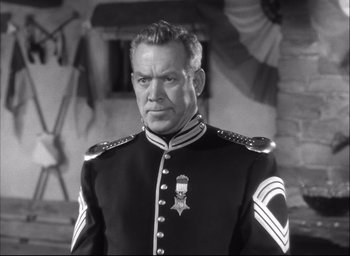 Movie still from “Fort Apache” (1948), directed by John Ford – A man in a military uniform stands in front of a building; Medium shot, Low angle