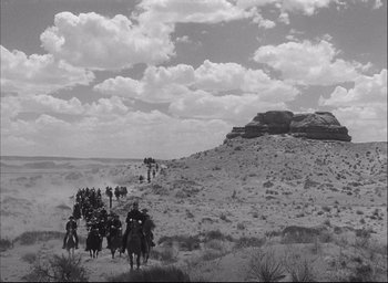 Movie still from “Fort Apache” (1948), directed by John Ford – A black and white photo of people on horses; Extreme Wide shot, Low angle