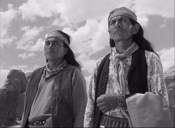Movie still from “Fort Apache” (1948), directed by John Ford – Two native american men standing next to each other; Medium shot, Low angle