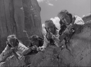 Movie still from “Fort Apache” (1948), directed by John Ford – A black and white photo of a group of people climbing a rock wall; Medium shot, Low angle