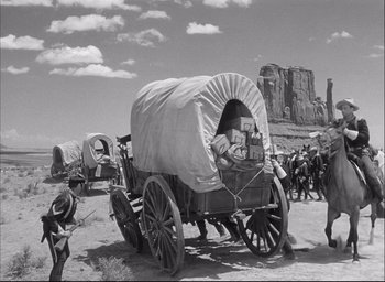 Movie still from “Fort Apache” (1948), directed by John Ford – An old photo of a covered wagon in the middle of the desert; Wide shot, Low angle