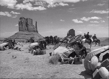 Movie still from “Fort Apache” (1948), directed by John Ford – A black and white photo of people in the desert; Wide shot, Over the shoulder angle