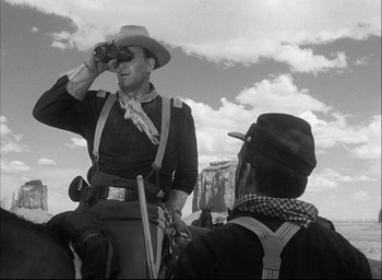 Movie still from “Fort Apache” (1948), directed by John Ford – A man on a horse looking into the distance; Medium shot, Low angle