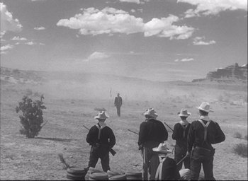 Movie still from “Fort Apache” (1948), directed by John Ford – A black and white photo of a group of men standing on a dirt field; Extreme Wide shot, Low angle