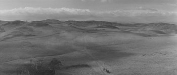 Movie still from “Forty Guns” (1957), directed by Samuel Fuller – An aerial view of a dirt road with a horse and buggy on it; Extreme Wide shot, High angle