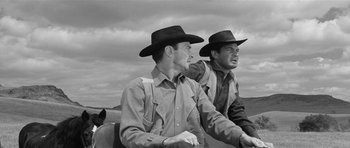 Movie still from “Forty Guns” (1957), directed by Samuel Fuller – A couple of men wearing cowboy hats riding a motorcycle; Medium shot, Low angle