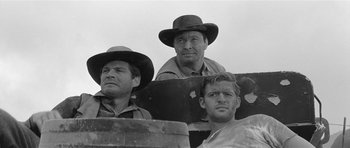 Movie still from “Forty Guns” (1957), directed by Samuel Fuller – A group of men standing next to each other in a field; Medium shot, Low angle
