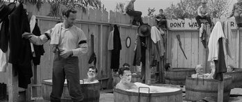 Movie still from “Forty Guns” (1957), directed by Samuel Fuller – A group of men bathing in an old fashioned tub; Wide shot, High angle