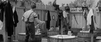 Movie still from “Forty Guns” (1957), directed by Samuel Fuller – A group of people hanging out in a tub of water; Wide shot, High angle