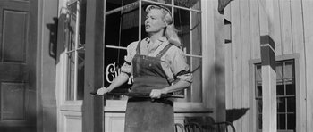 Movie still from “Forty Guns” (1957), directed by Samuel Fuller – An old photo of a woman holding a fork in her mouth; Medium shot, Low angle
