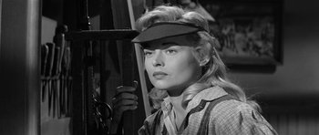 Movie still from “Forty Guns” (1957), directed by Samuel Fuller – A black - and - white photo of a woman holding a pair of shears; Close Up shot, Low angle