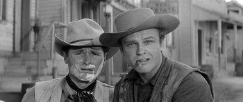 Movie still from “Forty Guns” (1957), directed by Samuel Fuller – Two men in cowboy hats are posing for a picture; Close Up shot, Over the shoulder angle