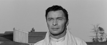 Movie still from “Forty Guns” (1957), directed by Samuel Fuller – Black and white photograph of a man with a towel around his neck; Close Up shot, Low angle