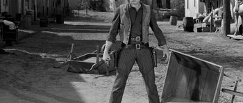 Movie still from “Forty Guns” (1957), directed by Samuel Fuller – A black and white photo of a man holding a gun; Medium shot, Low angle