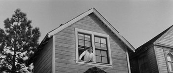 Movie still from “Forty Guns” (1957), directed by Samuel Fuller – A man standing in the window of a wooden house; Wide shot, Low angle