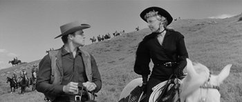 Movie still from “Forty Guns” (1957), directed by Samuel Fuller – A man and a woman are talking to each other while on horseback; Medium shot, Low angle