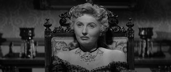 Movie still from “Forty Guns” (1957), directed by Samuel Fuller – An older woman wearing a dress and a necklace; Close Up shot, Low angle