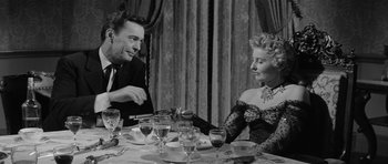 Movie still from “Forty Guns” (1957), directed by Samuel Fuller – A man and a woman sitting at a dinner table; Medium shot, High angle