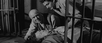 Movie still from “Forty Guns” (1957), directed by Samuel Fuller – A man laying on the ground with two other men; Medium shot, High angle