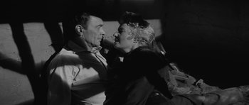 Movie still from “Forty Guns” (1957), directed by Samuel Fuller – An older man and a younger woman in a black - and - white photo; Medium shot, High angle