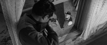 Movie still from “Forty Guns” (1957), directed by Samuel Fuller – A black and white photo of a man taking a picture of another man; Medium shot, Over the shoulder angle