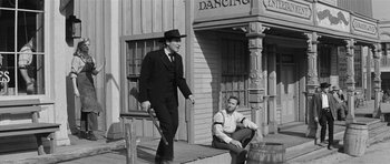 Movie still from “Forty Guns” (1957), directed by Samuel Fuller – A man in a suit and a man in a top hat; Wide shot, Low angle