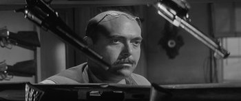 Movie still from “Forty Guns” (1957), directed by Samuel Fuller – A black and white photo of a man with glasses; Close Up shot, Low angle