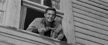 Movie still from “Forty Guns” (1957), directed by Samuel Fuller – A black and white photo of a man holding a gun; Medium shot, Low angle