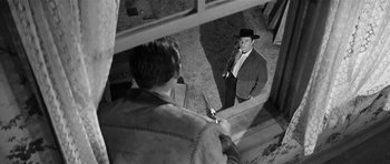 Movie still from “Forty Guns” (1957), directed by Samuel Fuller – A black and white photo of a man in a cowboy hat; Medium shot, Over the shoulder angle