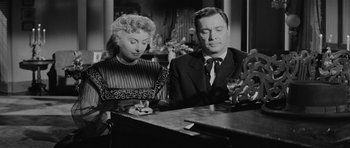 Movie still from “Forty Guns” (1957), directed by Samuel Fuller – A man and a woman sitting next to each other at a piano; Medium shot, Low angle