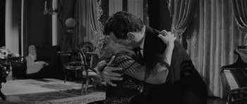 Movie still from “Forty Guns” (1957), directed by Samuel Fuller – A man and a woman are kissing in a room; Medium shot, Over the shoulder angle