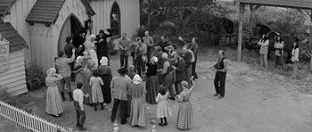 Movie still from “Forty Guns” (1957), directed by Samuel Fuller – A group of people standing around a building; Wide shot, High angle