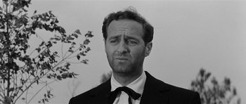 Movie still from “Forty Guns” (1957), directed by Samuel Fuller – Black and white photograph of a man wearing a suit and tie; Close Up shot, Low angle