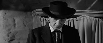 Movie still from “Forty Guns” (1957), directed by Samuel Fuller – A man in a suit and a black hat; Close Up shot, Low angle