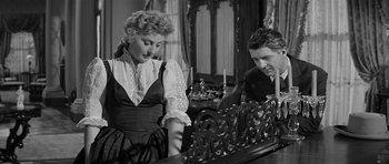 Movie still from “Forty Guns” (1957), directed by Samuel Fuller – A man and a woman are looking at a piece of furniture; Medium shot, Over the shoulder angle