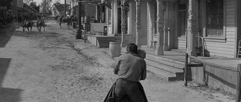 Movie still from “Forty Guns” (1957), directed by Samuel Fuller – An old photo of a man walking down the street; Wide shot, Over the shoulder angle