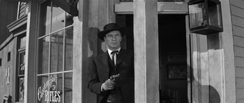 Movie still from “Forty Guns” (1957), directed by Samuel Fuller – A black and white photo of a man holding a gun; Medium shot, Low angle