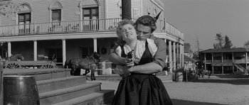 Movie still from “Forty Guns” (1957), directed by Samuel Fuller – A woman holding a gun while a man holds a horse; Medium shot, Low angle