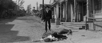 Movie still from “Forty Guns” (1957), directed by Samuel Fuller – An old black and white photo of a man and a woman laying on the ground; Wide shot, Low angle