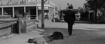 Movie still from “Forty Guns” (1957), directed by Samuel Fuller – An old photo of a man walking down the street; Wide shot, Low angle