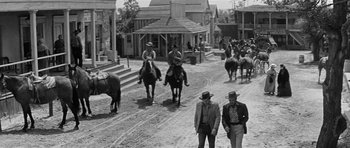 Movie still from “Forty Guns” (1957), directed by Samuel Fuller – A black and white photo of men on horses in a town; Wide shot, Low angle