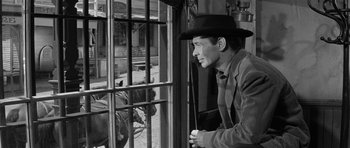 Movie still from “Forty Guns” (1957), directed by Samuel Fuller – A man looking out of a window at an animal; Medium shot, Over the shoulder angle