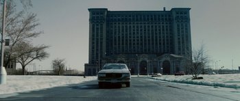 Movie still from “Four Brothers” (2005), directed by John Singleton – A car driving down a street near a large building; Extreme Wide shot, Low angle