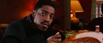Movie still from “Four Brothers” (2005), directed by John Singleton – A person sitting at a table with food; Close Up shot, High angle
