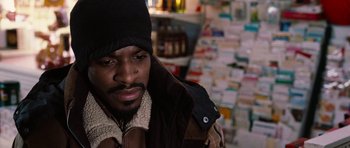 Movie still from “Four Brothers” (2005), directed by John Singleton – A man wearing a jacket and a hat in front of a bunch of cards; Close Up shot, High angle