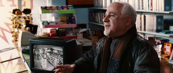 Movie still from “Four Brothers” (2005), directed by John Singleton – An older man sitting in front of a computer monitor; Medium shot, Over the shoulder angle